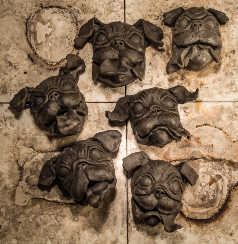 Ceramic pugs in varying stages of drying, soon to be painted.